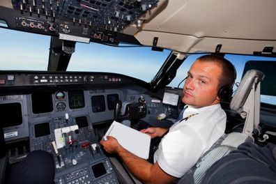 Young co-pilot at work in a cabin of commercial jet