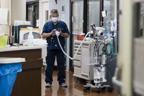 A healthcare worker holds an oxygen respirator tube in the Covid-19 Intensive Care Unit (ICU) at Freeman Hospital West in Joplin, Missouri, U.S., on Tuesday, Aug. 3, 2021. Hospitals in states where Covid-19 cases are once again surging are beginning to feel the strain in their emergency departments and intensive care units. Photographer: Angus Mordant/Bloomberg