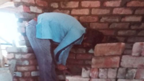 Jeff Marshall is pictured laying bricks as a young man. There no was protection against dust for workers.