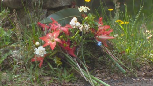 Flowers left by the house where twins were killed in a fire near Byron Bay, NSW.