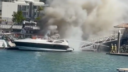 Firefighters are working to protect about half a dozen boats at Townsville's Marina after a parked boat caught fire this afternoon. 