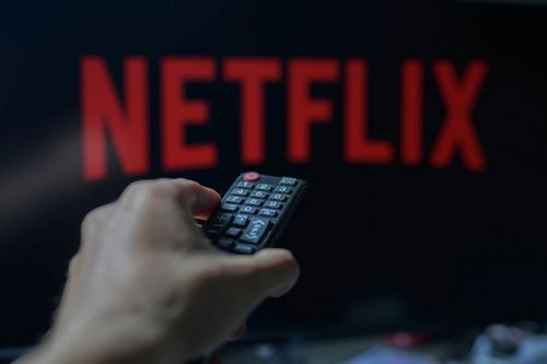 A personification is holding a TV distant pinch Netflix visible successful nan inheritance successful this photograph illustration taken successful Brussels, Belgium, connected May 5, 2024. (Photo by Jonathan Raa/NurPhoto)