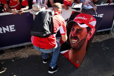 Sebastian Vettel signs a portrait of himself produced by a fan outside the Grand Prix. (AAP)