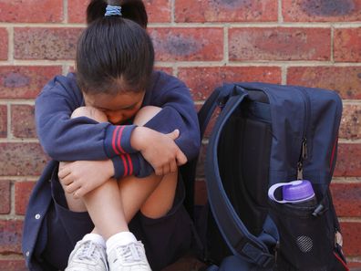 Young girl with backpack looking sad