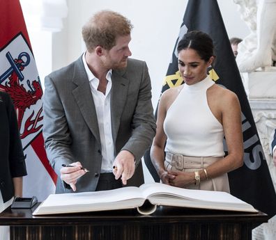 Prince Harry and Meghan, Duchess of Sussex sign the city's guest book at the town hall in Duesseldorf, Germany, Tuesday, September 6, 2022. 