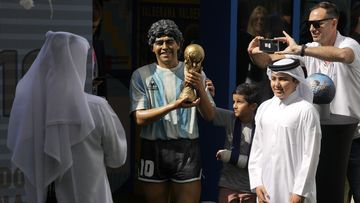 Children pose for a picture with a statue of the late soccer star Diego Maradona during a commemoration in his honor in Doha, in Friday, Nov. 25, 2022.