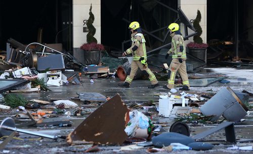 Emergency workers respond at the scene of a broken giant aquarium.