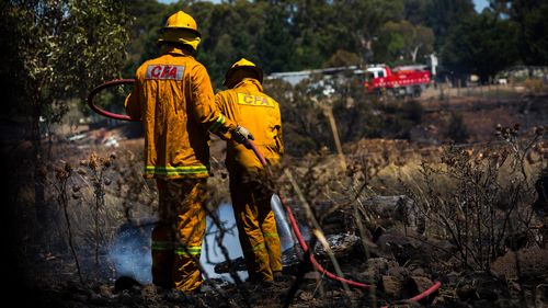 Fire crews are seen extinguishing an out of control grassfire in Melbourne
