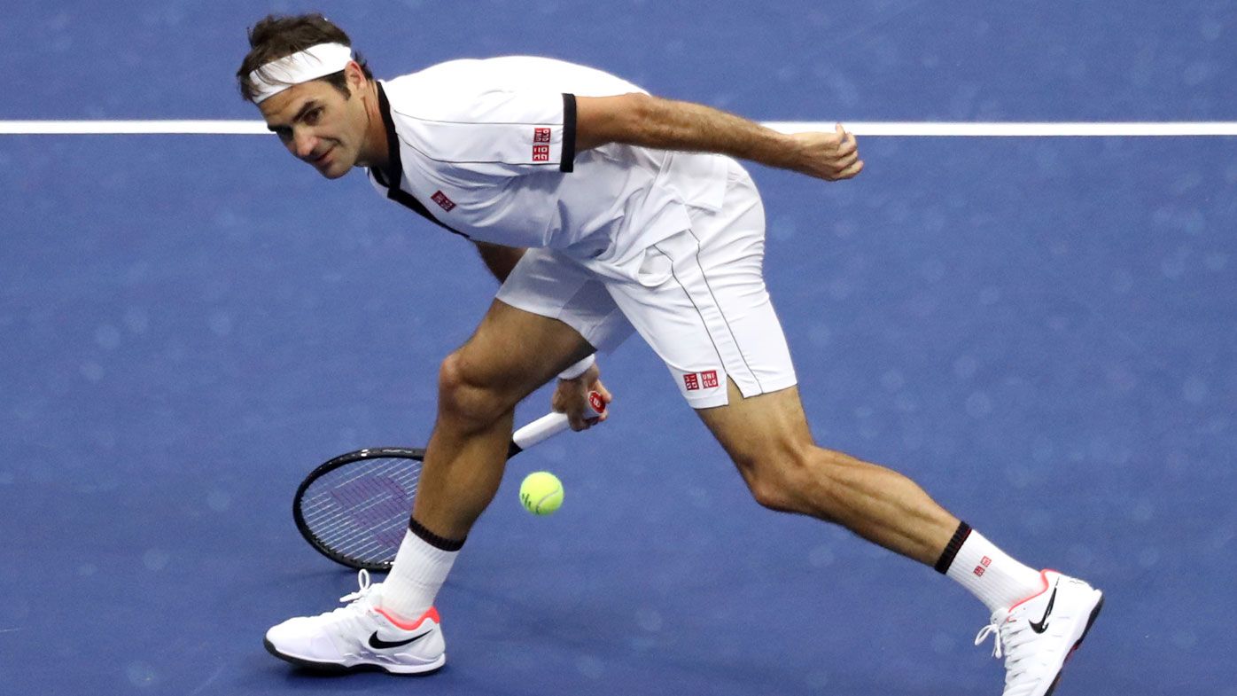Roger Federer of Switzerland reaches to return a shot against Damir Dzumhur