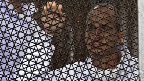 Australian journalist Peter Greste of Al-Jazeera looks on standing inside the defendants cage during his trial for allegedly supporting the Muslim Brotherhood. (Getty)