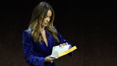 Olivia Wilde, director of the upcoming film "Don't Worry Darling," looks into an envelope handed to her onstage during the Warner Bros. Pictures presentation at CinemaCon 2022 at Caesars Palace, Tuesday, April 26, 2022, in Las Vegas. (AP Photo/Chris Pizzello)