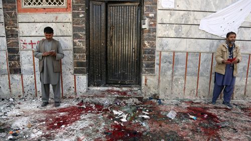 Afghans stand outside a voter registration centre after the suicide attack in Kabul, Afghanistan. (AP)