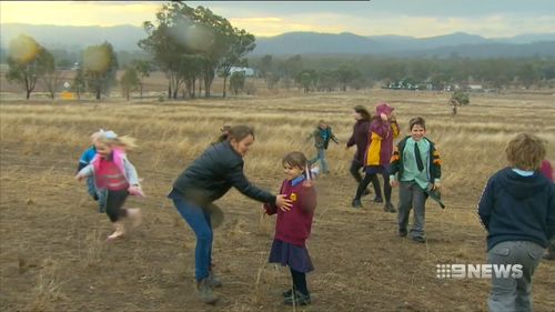 Locals dance in the rain, even if it was short lived. 10mm fell in Tamworth - it's the most rain they've had in six months. Picture: 9NEWS