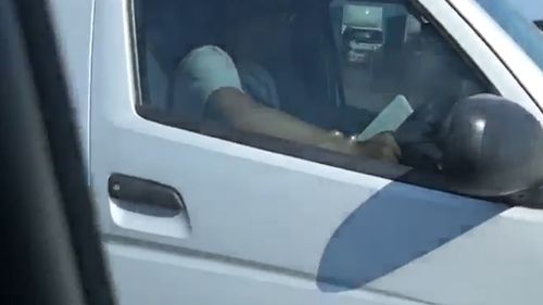 The driver was recorded with a book in one hand, and the steering wheel of the other van in the other.