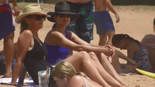 Princess Mary, in a royal blue swimsuit, chats to a friend in the sun.