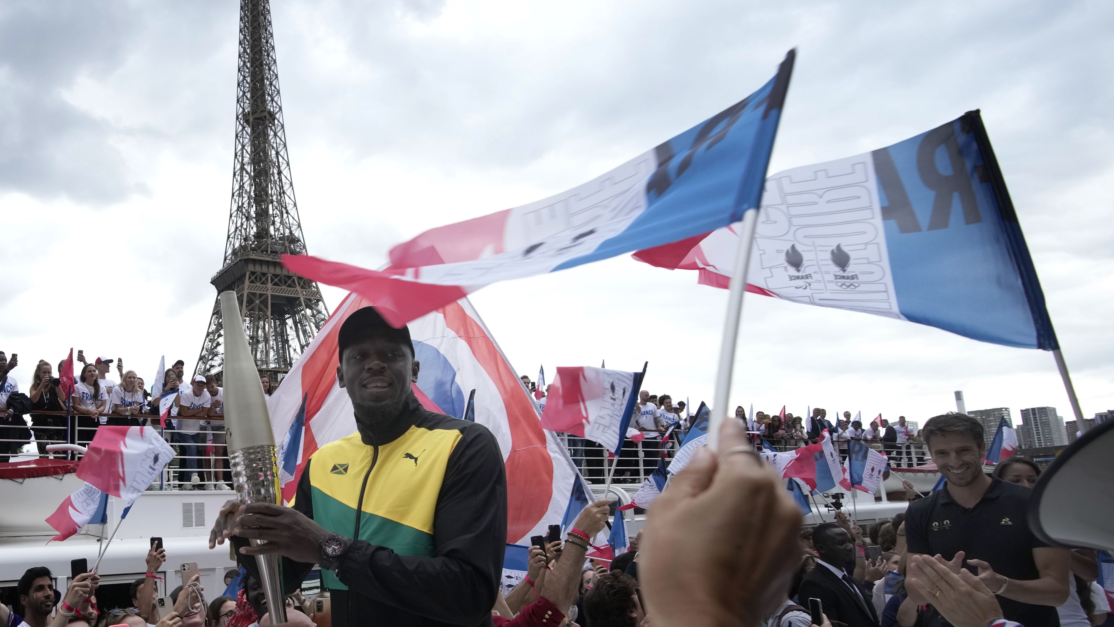 Olympics legend Usain Bolt with the torch as Paris celebrated one year until the 2024 Games.