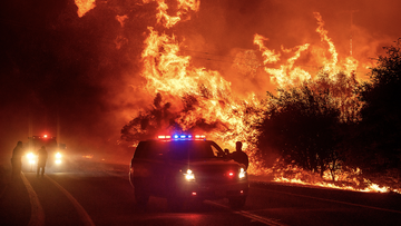 Flames lick above vehicles on Highway 162 as the Bear Fire burns in Oroville, Calif., on Wednesday, Sept. 9, 2020. (AP Photo/Noah Berger)