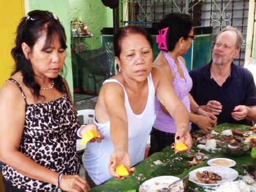 Paddock (far right) shares a meal with Marilou Danley's family in the Philippines. (Supplied)
