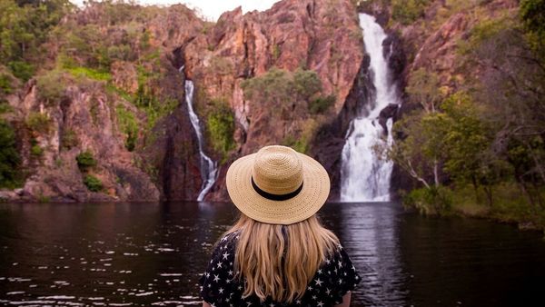 Woman standing in front of waterfall in the Northern Territory. 