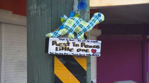 Tributes have been left on a street where a child was found dead in a hot car in Sydney.