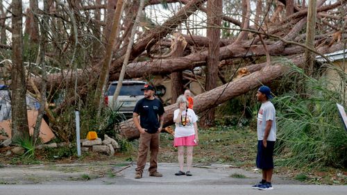 Joyce Fox stands in front of her heavily damaged home in the aftermath of Hurricane Michael in Panama City, Florida.