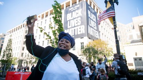 Una donna celebra il verdetto del processo di Derek Chauvin al Black Lives Matter Plaza vicino alla Casa Bianca il 20 aprile 2021 a Washington, DC.