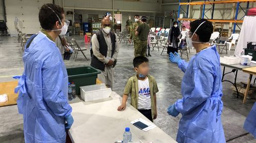 Australian Defence Force personnel process the first evacuees from Kabul, Afghanistan at Australia's main base in the Middle East region.