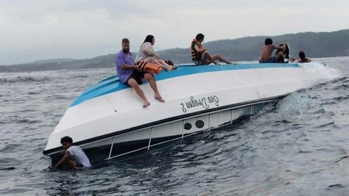 Passengers sit on a boat carrying tourists including a number of Australians that capsized in the waters off Nusa Penida Island, in Bali.