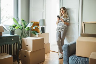 woman moves in to new home, unpacking boxes and enjoying in her new home