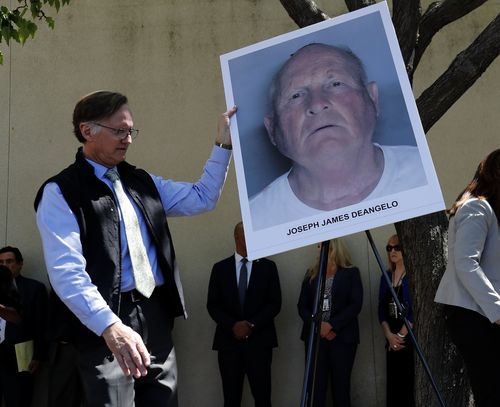 7 An official puts a mug shot on an easel stand, of the suspect identified as Joseph James DeAngelo. (AAP)