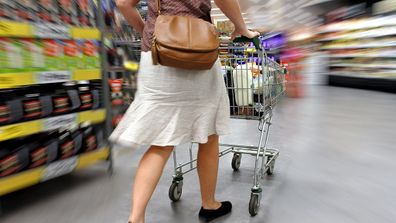 Woman pushing shopping trolley at supermarket