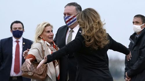 U.S. Secretary of State Mike Pompeo, center, and his wife Susan, right, embrace U.S. Ambassador to France Jamie McCourt, left, after stepping off a plane at Paris Le Bourget Airport, Saturday, Nov. 14, 2020, in Le Bourget, France.