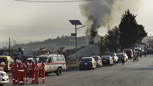 Lebanese Red Cross volunteers gather at a street next to the scene where a fuel tanker exploded in Tleil village.
