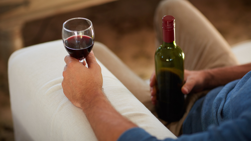 Man drinking red wine and holding a bottle