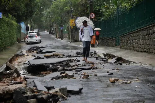 A street in Rio damaged by heavy rains. Officials closed schools and urged people to avoid non-essential traffic. (Silvia Izquierdo/Associated Press)