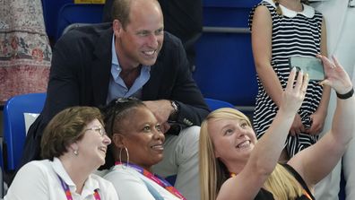 Princess Charlotte, center right, looks as Britain's Prince William, center, poses for a selfie with spectators during a swimming event at Sandwell Aquatics Center on day five of the 2022 Commonwealth Games in Birmingham, England, Tuesday, Aug. 2 , 2022