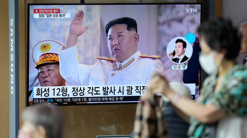 A TV screen showing a news program reporting about North Korea's missile launch with file footage of North Korean leader Kim Jong Un, is seen at the Seoul Railway Station