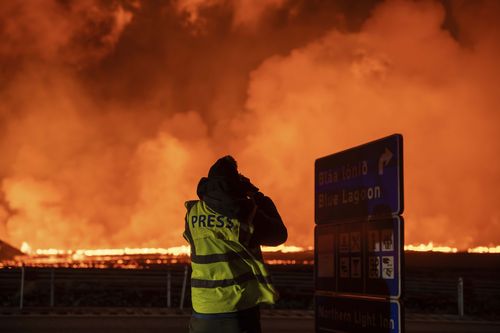 Fotoğrafçılar ve gazeteciler, İzlanda'nın Grindavik kentinin kuzeyindeki yeni çatlağı filme alıp rapor ediyor, 22 Ağustos 2024 Perşembe, (AP Photo/Marco di Marco)