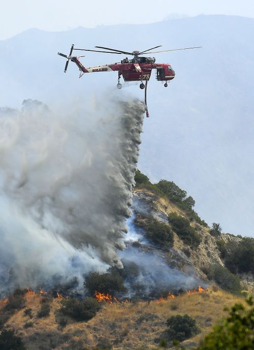 A Skycrane helicopter drops water on a hotspot in Burbank, California. (Associated Press)