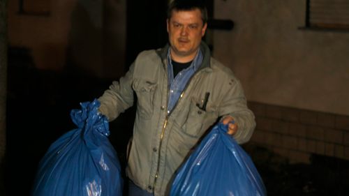An investigator carries bags from the home of the family of Andreas Lubitz. (AAP)