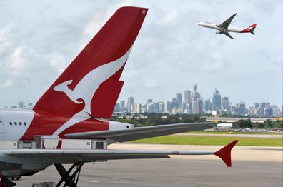 "Sydney, Australia - March, 14th 2012: Qantas aeroplanes and tail fin with the distant view of downtown Sydney - Sydney Airport"