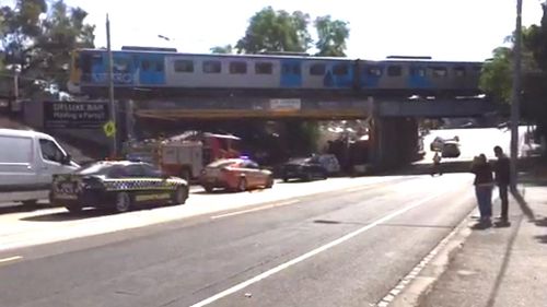 Garbage truck crashes into rail bridge, driver trapped