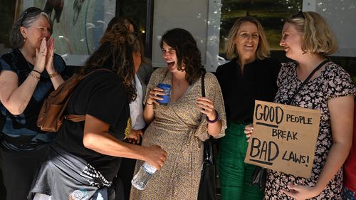 CoCo (centre) with supporters outside at the Downing Centre Local Court in Sydney on Wednesday.