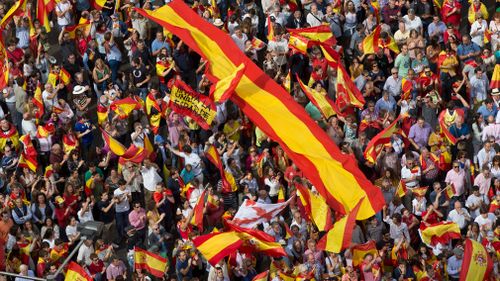 Thousands of pro-Spanish unity supporters donning Spanish flags have rallied in a central Madrid plaza to protest the Catalan regional government's drive to separate from Spain. (AP)