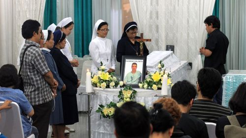 An Indonesian clergyman, nuns and mourners pray in front of Brazilian Rodrigo Gularte's coffin at Saint Carolus funeral Home in Jakarta, Indonesia. (AAP)