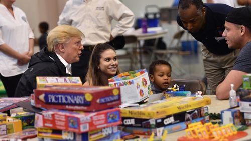 Mr Trump and several children at the shelter. (AFP)