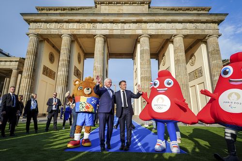 French President Emmanuel Macron, right, and German President Frank-Walter Steinmeier stand in front of the Brandenburg Gate with the mascots for the European soccer Championship and the Olympic Games in Berlin Sunday, May 26, 2024. (Kay Nietfeld/dpa via AP)