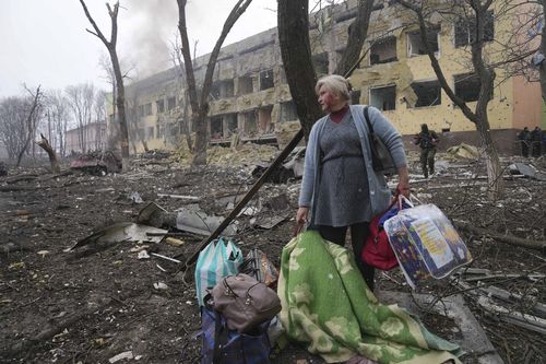 A woman walks outside a maternity hospital that was damaged by shelling in Mariupol, Ukraine, Wednesday, March 9, 2022. 