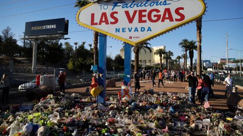 Flowers, candles and other items surround the famous Las Vegas sign at a makeshift memorial for victims of the mass shooting. (AP)