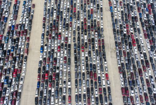 People wait in their cars at Traders Village for the San Antonio Food Bank to begin food distribution. The need for emergency food aid has exploded in recent weeks due to the COVID-19 coronavirus epidemic.